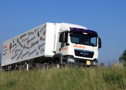 Migros Lastwagen in Landschaft Camione in viaggio
